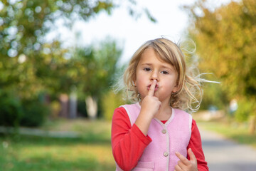 Fototapeta premium Child pointing quietly on the street. Selective focus.