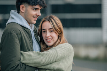 young couple in love hugging on the street