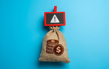 Money bag and warning sign. Emergency funds. The problem of legality and legitimate origin....