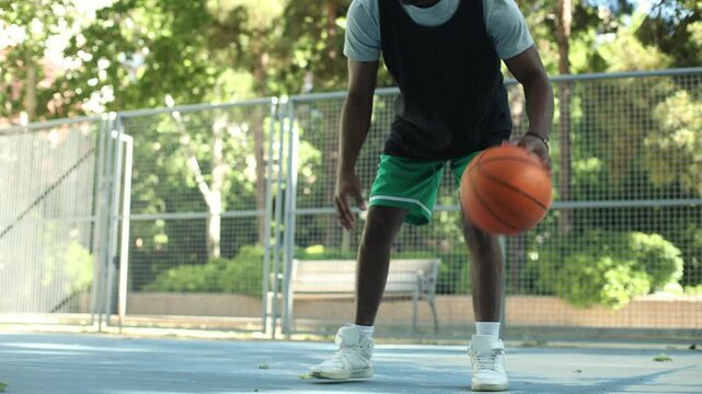 Basketball player dribbling on outdoor court