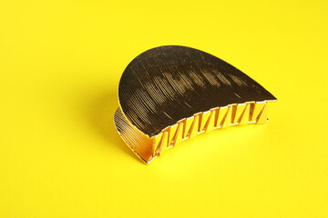 Beautiful bijouterie. Stylish hair clip on yellow background