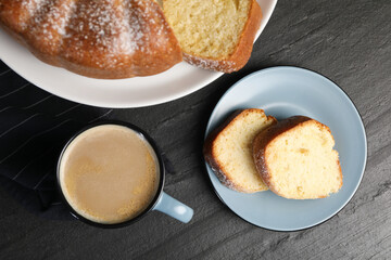 Freshly baked sponge cake and coffee on black table, top view