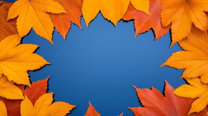 Fototapeta premium Autumn Leaves Frame: A vibrant autumnal frame of fiery red and golden leaves creates a warm and inviting space against a backdrop of clear blue sky.