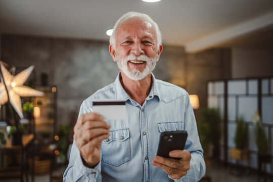 senior mature man buy online on cellphone with credit card at home