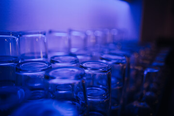 Glasses stand on the table at the. bar with backlight