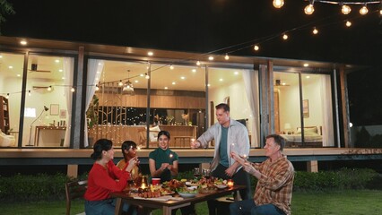 Happy family holding glowed sparkler in holiday celebration party at night. Lovely member enjoy playing spark toy together. Outdoor activity to cross generation gap strengthen family bond. Divergence.