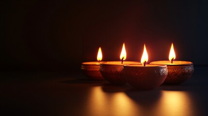 Four beautifully crafted clay oil lamps glowing in the dark, creating a serene and warm atmosphere.