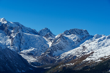 Picturesque landscape in Dombay with amazing snow-capped peaks and majestic blue slopes of North Caucasus Mountains. Mountain ski resort in Karachay-Cherkessia, Russia