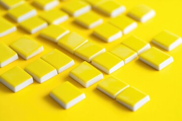 A collection of yellow and white tiles on a bright yellow surface