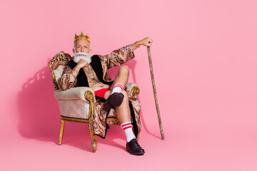 Photo of confident thoughtful man casino winner wear stylish print costume sitting king throne...