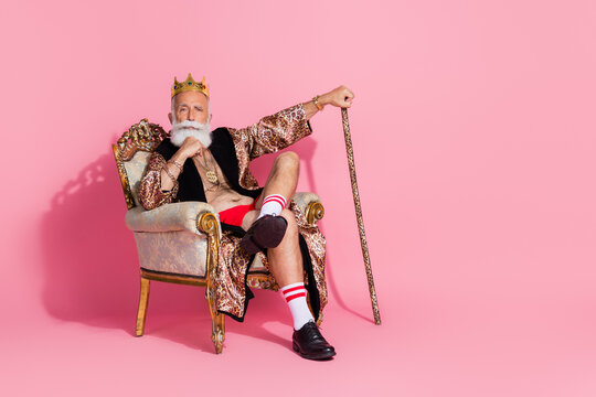 Photo of confident thoughtful man casino winner wear stylish print costume sitting king throne isolated on pink color background