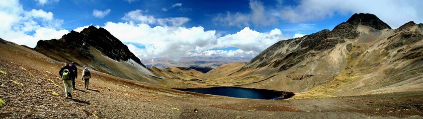 Hikers in Bolivia's Rugged Terrain
Andes mountains under a bright blue sky with scattered clouds in Bolivia.