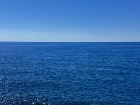 Open sea blue calm water and cloudless sky.