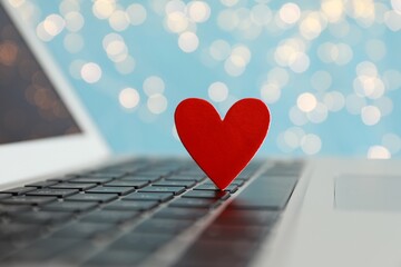 Decorative heart on laptop keyboard, closeup. Online dating concept