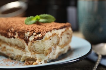 Piece of tasty tiramisu on table, closeup