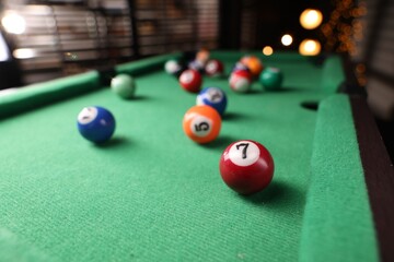 Many colorful billiard balls on green table indoors, closeup
