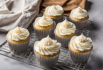 Multiple fresh vanilla birthday cupcakes with white paper wrappers, whipped cream frosting