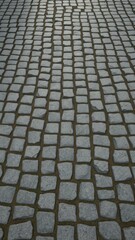 Fototapeta premium Irregular, grey cobblestones forming a textured street pavement, design,old