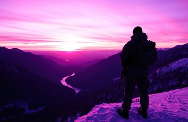 Soldier stands on snowy mountain peak at purple sunset. Majestic landscape with river winding through valley. Dramatic colours. Peaceful scene. Military man observes nature.