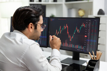 Smart trader businessman analyzing in two dynamic stock exchange investment screen on pc with investing highest profitable financial technology in searching market at modern home office. Surmise.