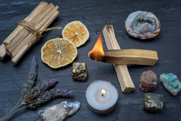 Ritual objects for spiritual practice, Palo Santo, candle and crystal on black stone background