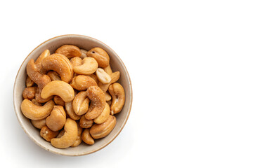 Fototapeta premium Bowl of Golden-Brown Roasted Cashews Positioned Left Side on White Background with Copy Space