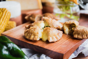 cheese empanadas cut in half served on wooden board. Close up