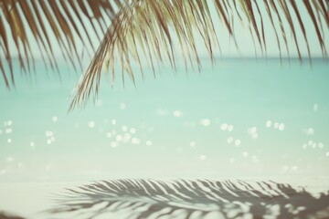 Blurred palm leaves frame a sunlit beach, creating a dreamy, tranquil scene of sand, sea, and sky, invoking a sense of escape.