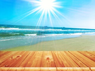 Wooden table on the background of the sand beach with over blue sea and sky in summer day.