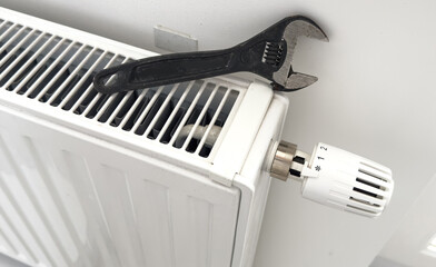 tools on the radiator. water heating radiator on the white wall indoors.
