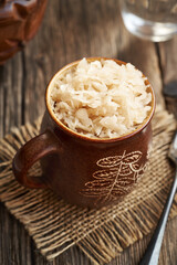 Homemade fermented cabbage or sauerkraut in a brown cup