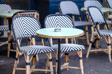 Traditional empty chairs and tables outdoors at a bistro restaurant in Paris France 