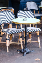 Traditional empty chairs and tables outdoors at a bistro restaurant in Paris France