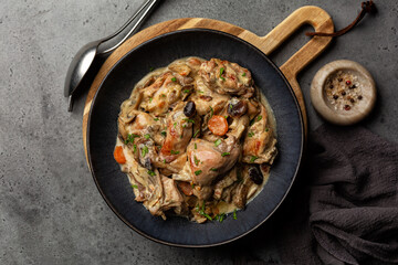 Creamy rabbit and mushrooms stew in a sauce of wine and cream with onion and carrot. Top view.