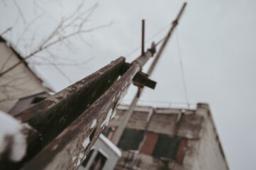 a gloomy winter shot of a metal cable supporting a rusty pipe in the heating room of factory shops...
