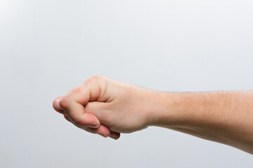 A close-up of a person's hand gently clenched into a loose fist. The image is set against a simple, light gray backdrop, focusing attention on the hand's position and form.