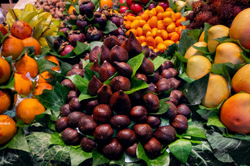 Close-up of a heap of salak fruit at a market, exotic snake fruit.