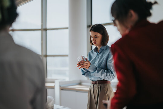 A businesswoman attentively examines a product sample during a team meeting in a modern office. The image captures a multicultural team collaborating. Ideal for concepts of focus, teamwork, and - Powered by Adobe