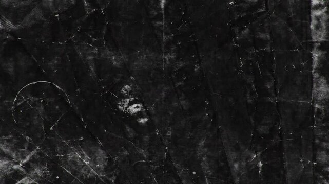 Abstract monochromatic animation of burnt paper. Black background. Seamless loop. Slideshow. Low frame rate effect.