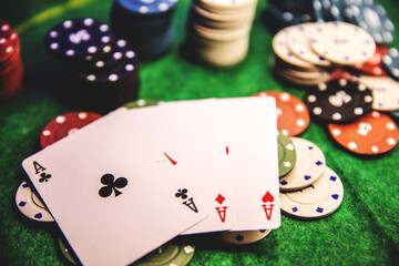 close up of casino chips with cards and dice on a green table