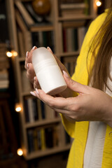 A close-up of hands holding a roll-on natural deodorant. Highlighting eco-consciousness, personal hygiene, and simple design.