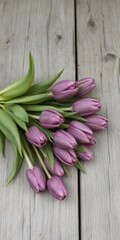 A bouquet of purple tulips rests on weathered, grey wood, purple,nature