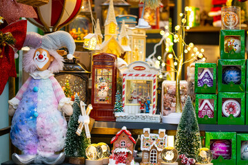 Christmas plush toys on the shelf in the store for sale. Christmas decorations in the shopping mall. Plush clowns, houses and souvenirs are displayed in the store for Christmas and New Year.