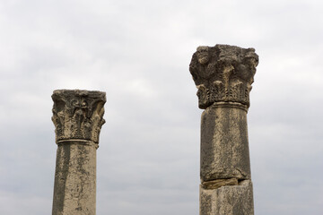 Ancient Ruins, Majestic Columns Against a Cloudy Sky. Stone columns reach for the sky, lost civilization, copy space, selective focus