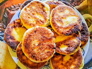Homemade fried cheesecakes on a plate on the table, top view