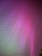 Fototapeta premium Aurora borealis over the skys of Devon in England in pretty pinks and green a very rare sight 