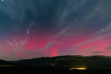 Vibrant red aurora borealis painting the night sky above Serra Del Montsec, Lleida, Spain. October...