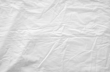 Top view of wrinkles on an unmade bed sheet after waking up in the morning.