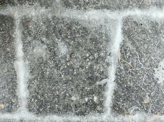 Ice crust on the pavement, paving stones, frozen water on a pavers