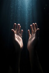 Submerged hands reach upward, light above.